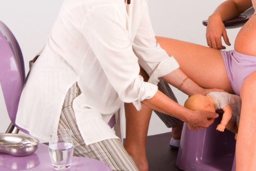 Midwife semi-sitting, semi-kneeling on Midwife Chair