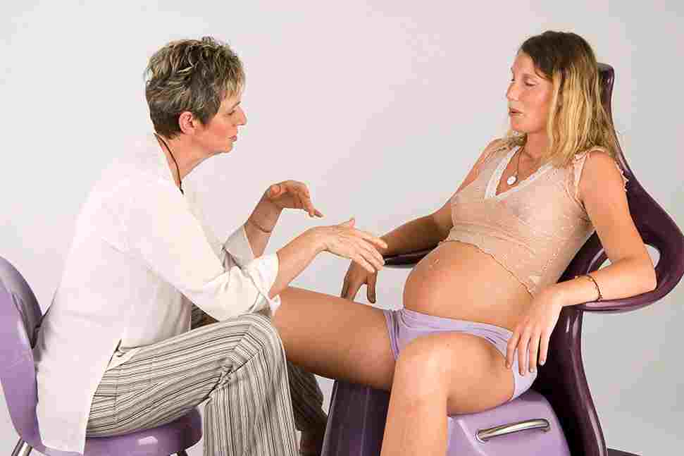 Image of midwife encouraging woman to breathe baby down
