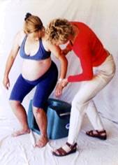 Photo of midwife lowering woman onto the Seat